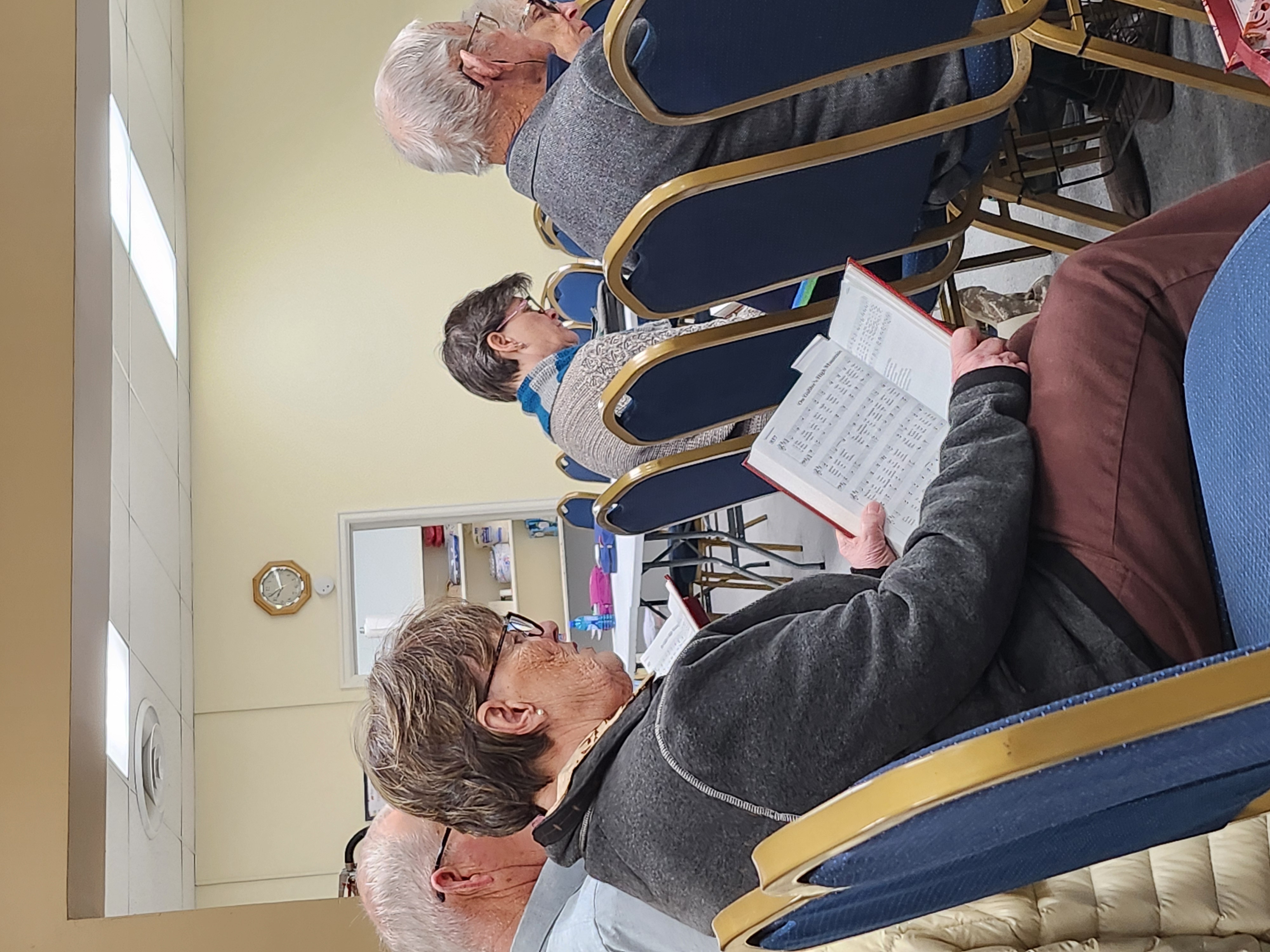 Some members of Christ the King singing hymns from the hymnal during worship